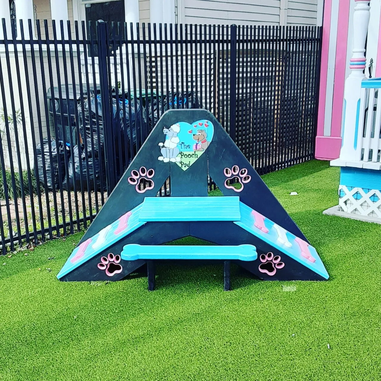 Colorful dog agility ramp on grass.